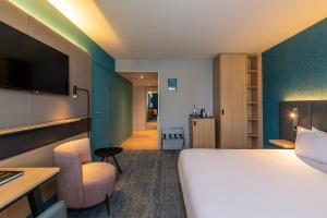 a hotel room with a bed and a tv at Holiday Inn Reims Centre, an IHG Hotel in Reims