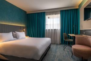 a hotel room with a large bed and a large window at Holiday Inn Reims Centre, an IHG Hotel in Reims