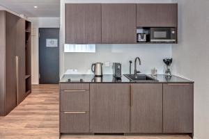 a kitchen with brown cabinets and a counter top at MOOI Apartments Schlieren in Schlieren