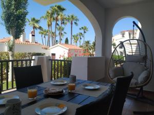 a table with food and drinks on a balcony with palm trees at Apartamento recién reformado en Cala en Porter in Cala en Porter