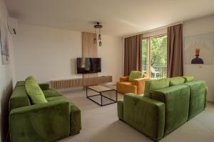 a living room with two green chairs and a television at Vertmont Villa in Sveti Stefan
