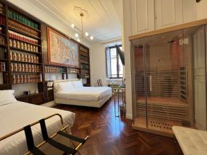 a bedroom with two beds and a room with books at Navona Central Suites in Rome