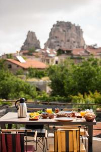 uma mesa com pratos de comida com montanhas ao fundo em Ahiyan Hotel em Üçhisar