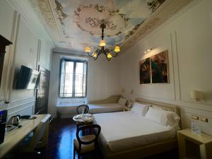 ein Schlafzimmer mit einem Bett, einem Tisch und einem Kronleuchter in der Unterkunft Navona Central Suites in Rom