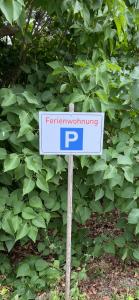 a parking sign in front of a green bush at Ferienwohnung Eichhörnchen in Suhl