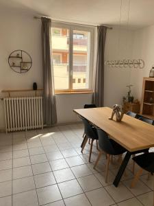 a dining room with a table and chairs and a window at APPARTEMENT SPACIEUX in Orange