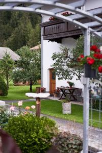 a garden with a house and a table with flowers at Appartement Trujen in Längenfeld