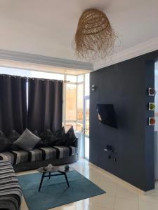 - un salon avec un canapé et un mur bleu dans l'établissement Large Sea view studio, à Agadir