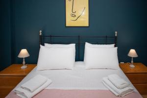 a bedroom with a bed with white sheets and pillows at Santa Marina in Ioannina