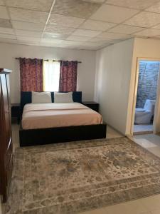 a bedroom with a bed and a window and a rug at Sky Inn Hotel in Freetown +16 photos