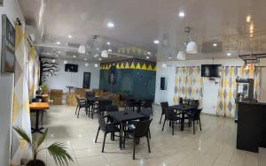 a dining room with tables and chairs in a restaurant at Sky Inn Hotel in Freetown