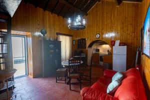 a living room with a red couch and a kitchen at Aurora House in Mosteiros