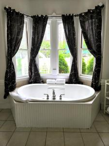 La salle de bains est pourvue d'une baignoire et d'une fenêtre. dans l'établissement Belfry Inn and Bistro, à Sandwich