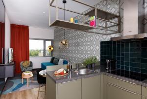 a kitchen with a sink and a living room at Boutique Apartments Amsterdam in Amsterdam