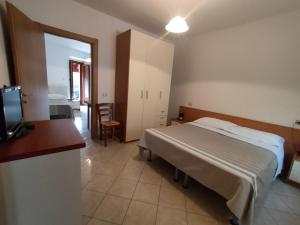 ein Schlafzimmer mit einem Bett und einem TV. in der Unterkunft Il Narciso appartamenti in Assergi