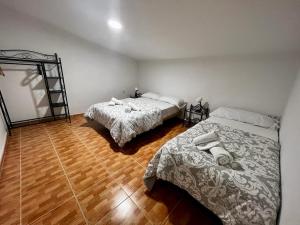 1 dormitorio con 2 camas y suelo de madera en Atico CabezoDoce, en Calahorra