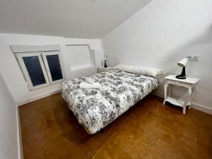 a bedroom with a bed and a table and a window at Atico CabezoDoce in Calahorra