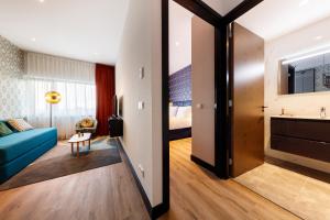 een woonkamer met een blauwe bank en een bed bij Boutique Apartments Amsterdam in Amsterdam