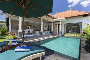 een villa met een zwembad en een huis bij Villa Tulip in Sanur