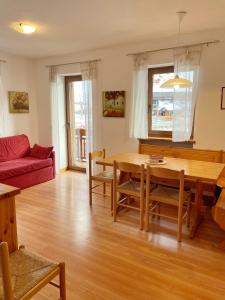 阿萊蓋的住宿－Casa Nili，客厅配有桌子和红色沙发