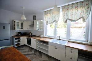 a kitchen with a sink and a large window at Levendula ház - Rosie Home in Balatonlelle
