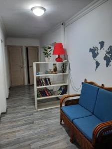 sala de estar con sofá azul y estante para libros en Ohana Boutique, en Astana
