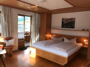 a bedroom with a bed and a large window at Haus Petra in Oberjoch