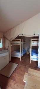 a room with two bunk beds and a wooden floor at La lodge du Refuge in Valigny