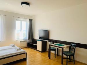 a room with a bed and a table and a tv at Dovolená bez starostí - Apartmány u Venuše in Pavlov