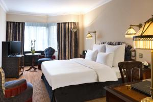 a hotel room with a large bed and a desk at Hotel Barsey by Warwick in Brussels