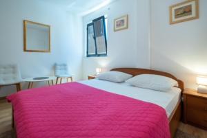 1 dormitorio con 1 cama grande con manta rosa en Guest House Kono, en Dubrovnik