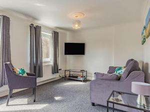 a living room with a couch and a tv at Lovely Apartment 3 King-size beds in Torquay