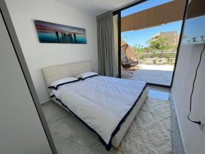 um quarto com uma cama e uma grande janela em lasuita-exclusive suites ceserea-luxury suite em Caesarea