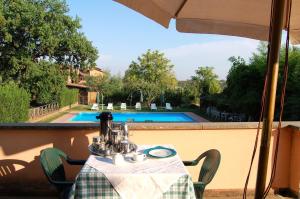 a table with a tea kettle on a balcony with a pool at Casa Grion in Corchiano