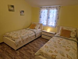 two beds in a small room with a window at Apartments Marija in Vir +108 photos