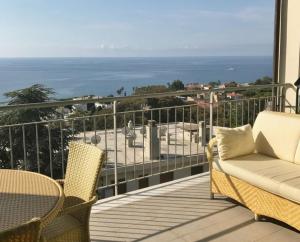 einen Balkon mit einem Sofa, Stühlen und Meerblick in der Unterkunft Carlo's BA27 - Sanremo Attico Cielo Mare - in Sanremo