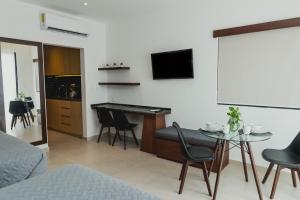 a bedroom with a desk and a table with chairs at Phantom Suites in Playa del Carmen