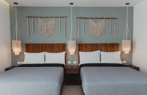 two beds in a hotel room with at Phantom Suites in Playa del Carmen