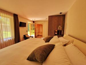una camera da letto con un grande letto bianco con cuscini di Chalet La Ciaseta a Pozza di Fassa