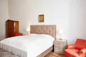 霍恩的住宿－Exklusiver, privater Schlosstrakt im Schloss Horn，卧室配有白色的床和红色椅子