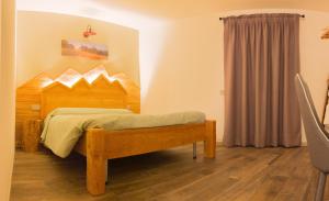 テーリオにあるCa' di Pazientのベッドルーム1室(木製ヘッドボード付きのベッド1台付)