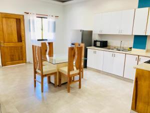 een keuken met een tafel en stoelen en een koelkast bij Flat Aquamare Monte Vista in Sosúa