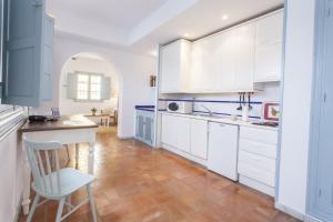 a kitchen with white cabinets and a wooden floor at Apartamentos Suites Santa Cruz in Seville +15 photos