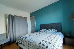 a bedroom with a bed with a blue wall at AL 11 - Villa "La Lisette" 8 personnes in Ault