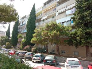 uma fila de carros estacionados num parque de estacionamento em Artistic chill art apartment 2+2.Centar of Split. em Split