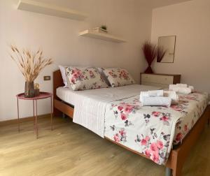 sypialnia z łóżkiem z narzutą w kwiaty w obiekcie CLO APARTMENT w mieście Toscolano Maderno