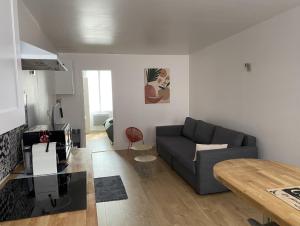 a living room with a couch and a table at Le Petit Cesar in Hautvillers