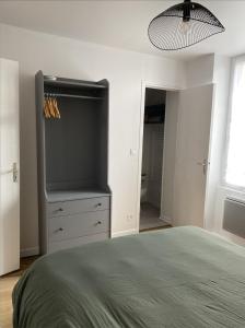 a bedroom with a bed and a dresser with a television at Le Petit Cesar in Hautvillers