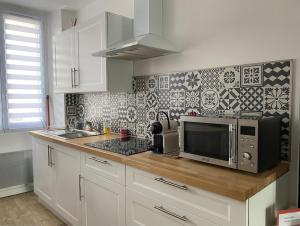 a kitchen with a microwave and a sink in it at Le Petit Cesar in Hautvillers