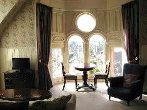 a living room with a table and chairs and a window at Shaftesbury Hotel Dundee in Dundee